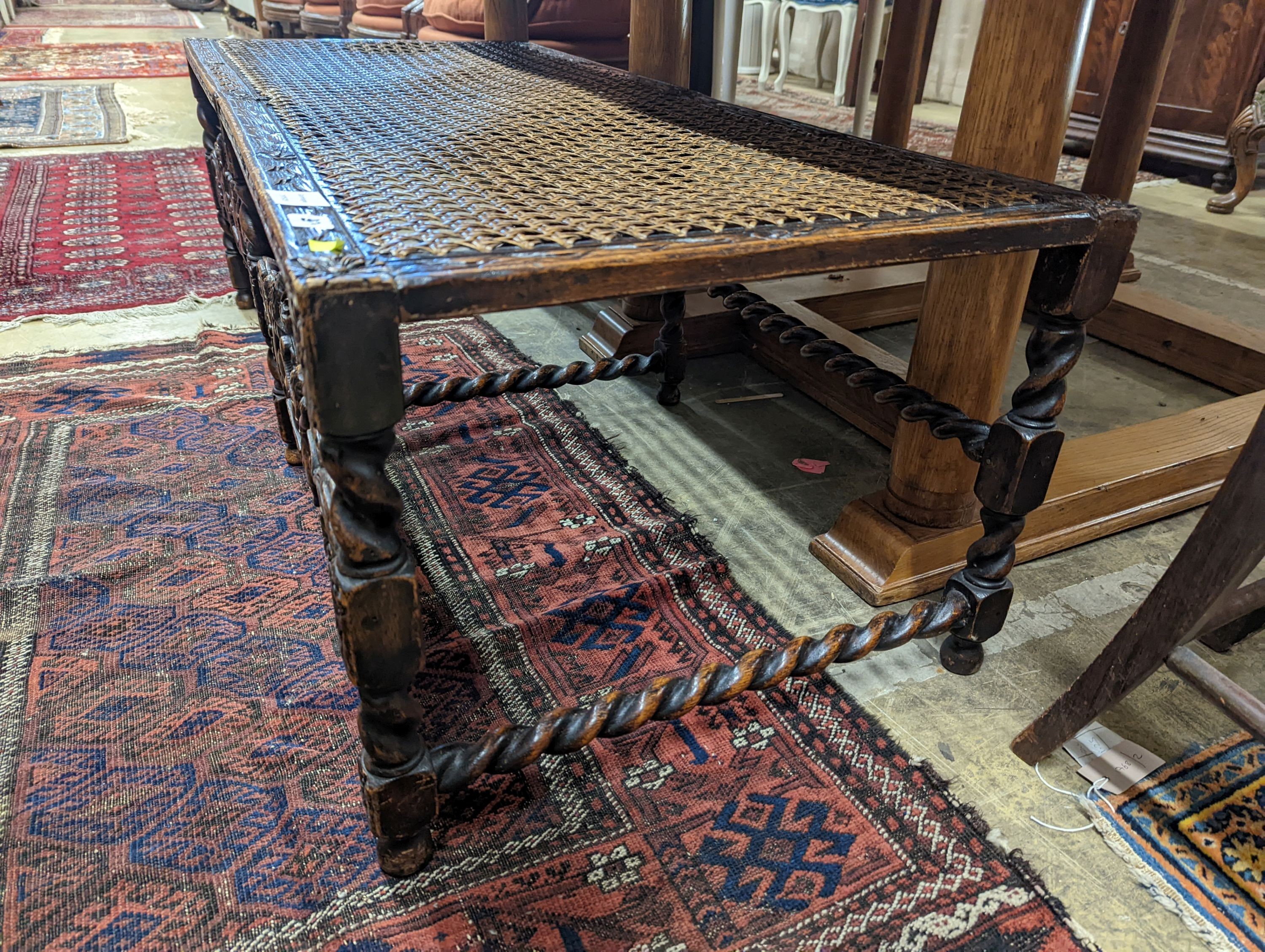 A 1920's Carolean style oak and cane work window seat, length 130cm, depth 58cm, height 44cm